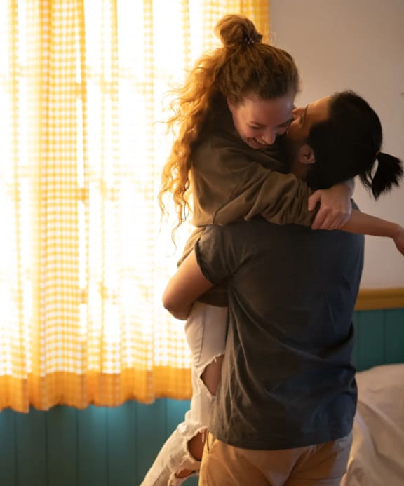 a couple hugging in a hotel room