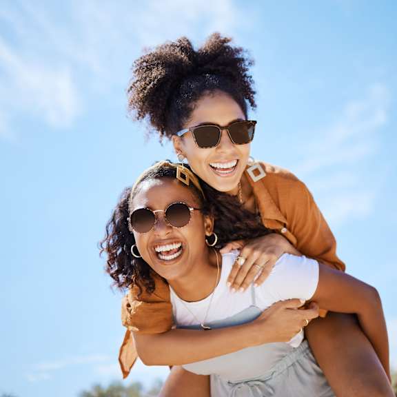 Two people are enjoying a piggyback ride outdoors.