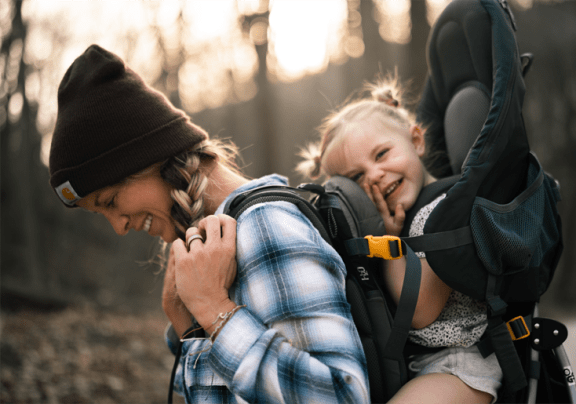 a mother carrying her child in a baby carrier