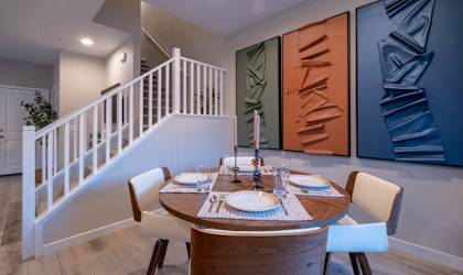 A dining room with a round table set for two.