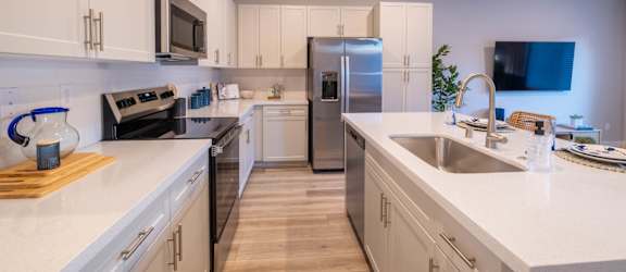 A modern kitchen with white cabinets and stainless steel appliances.
