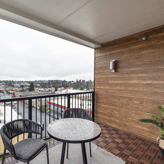 a patio with a table and chairs overlooking the city at Elevation16 Apartments, Washington