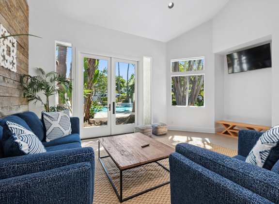 A living room with blue couches and a wooden coffee table.