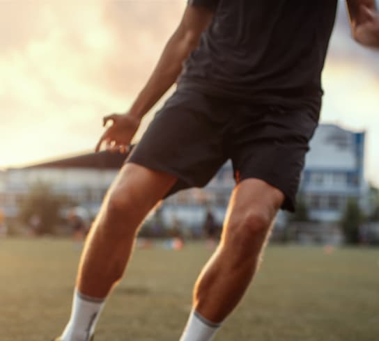 A man is about to kick a soccer ball on a field.