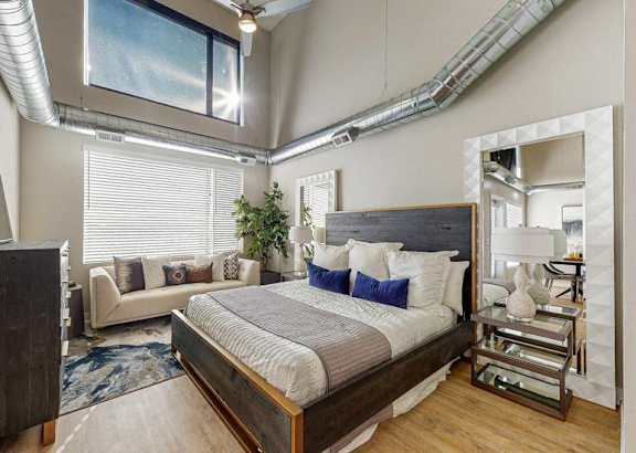 A bedroom with a large bed and a ceiling fan.at Linc, Iowa, 50309