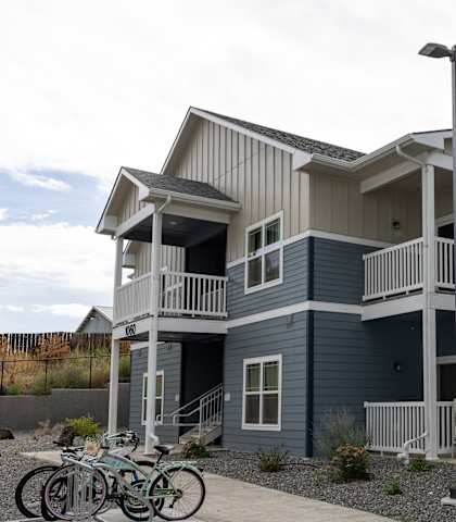 A two-story building with a balcony and a bicycle parked in front.