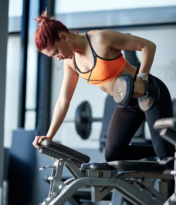 A black weight bench with a barbell on it.