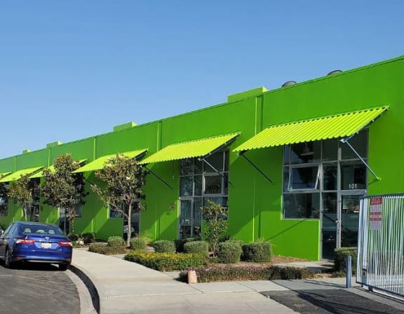 a bright green building with green shutters and a street light