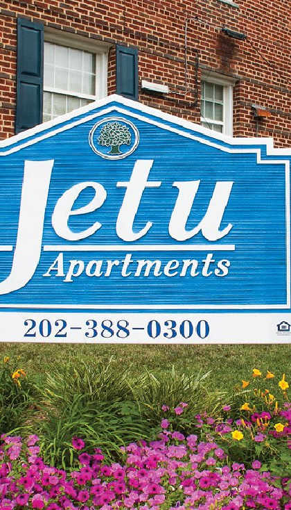 a blue sign in front of a building with pink flowers