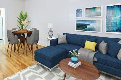 a living room with a blue couch and a dining room table