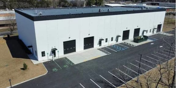 an aerial view of a white building with a parking lot