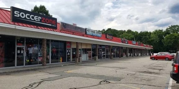 a store with a red car parked in front of it