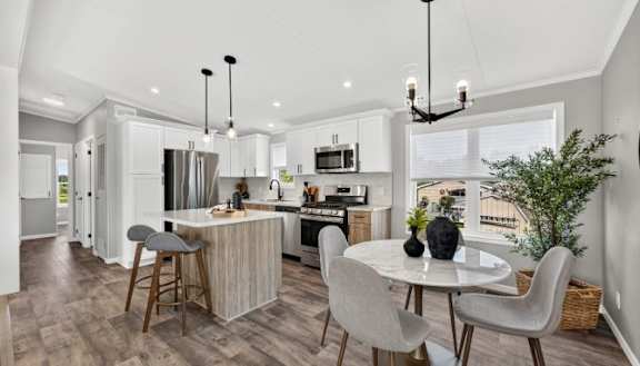 A modern kitchen with a wooden table and black chairs.