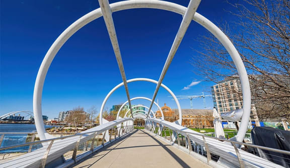 a bridge over a body of water with a city in the background