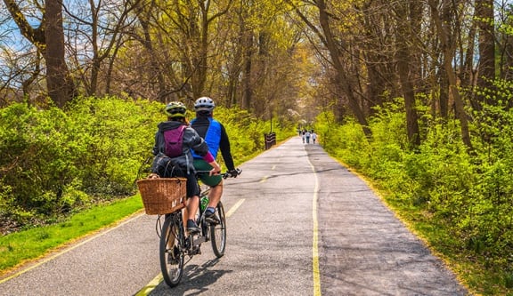 a couple of people riding bikes down a road