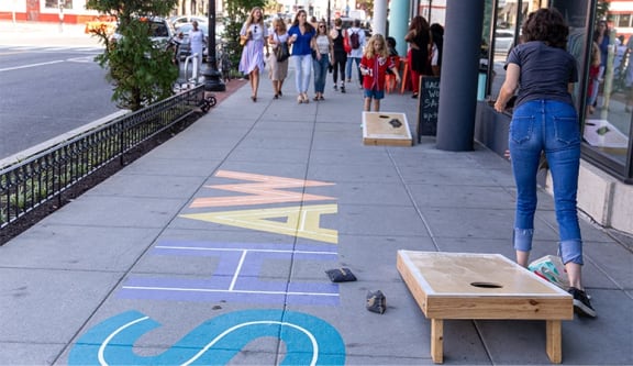 a group of people walking down a sidewalk