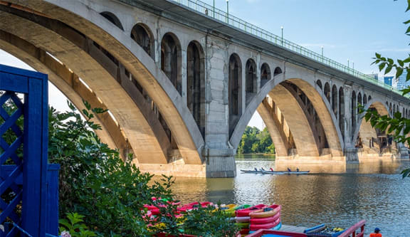 a river with boats under a bridge