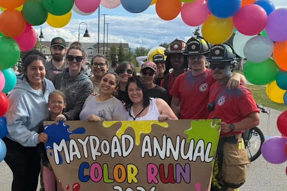 A group of people are posing in front of a sign that says "Back to School Bash".