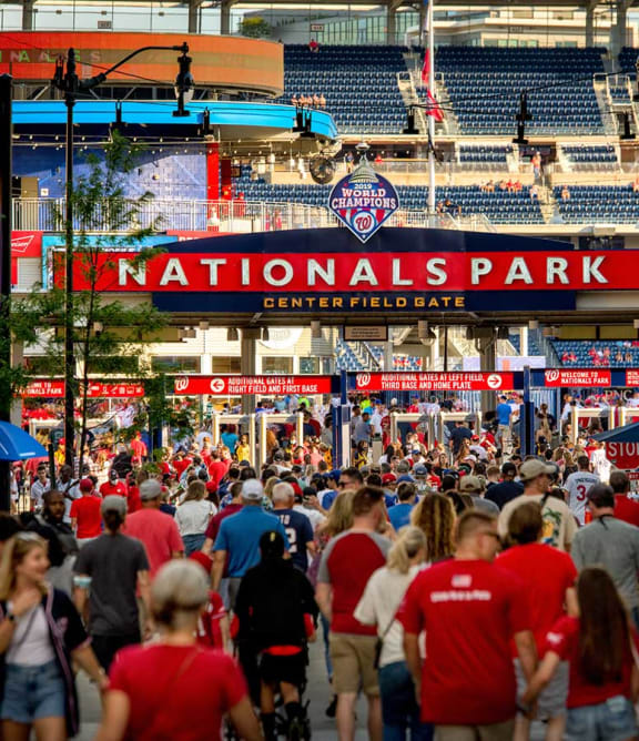 a large crowd of people walking down a street at nationals park