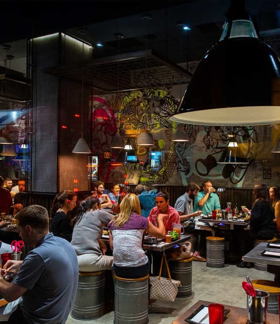 a group of people sitting at tables in a restaurant