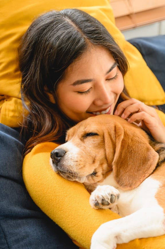 a woman sleeping on a couch with her dog