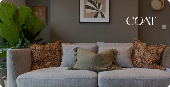 a couch with pillows and a plant in a living room