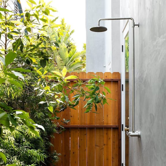 a wooden deck next to a building with a shower