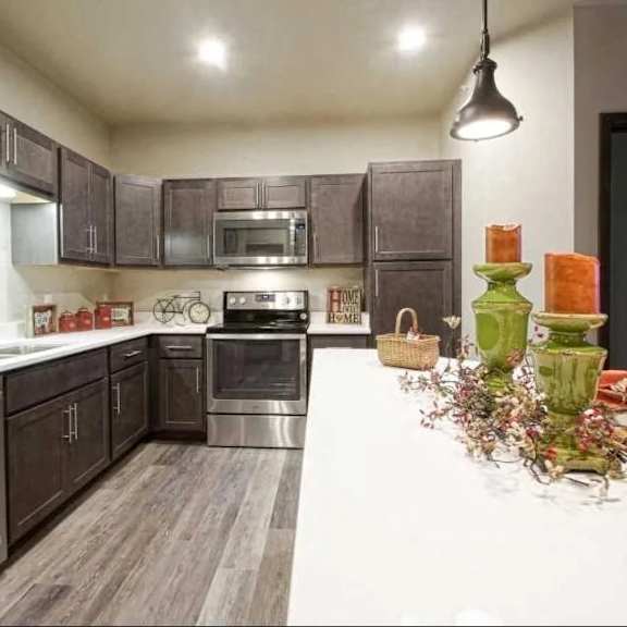 A kitchen with dark wood cabinets and stainless steel appliances.