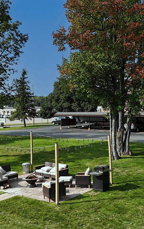 A park area with a lawn, trees, and a picnic table.