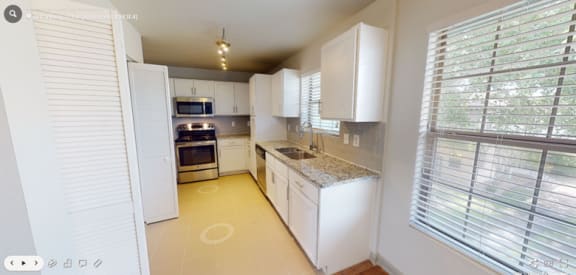 a kitchen with white cabinets and a yellow floor  at Sunset Ridge, San Antonio, 78209