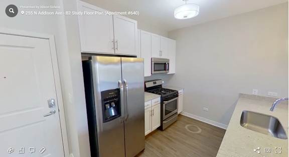 A kitchen with a refrigerator, microwave, oven, and sink.