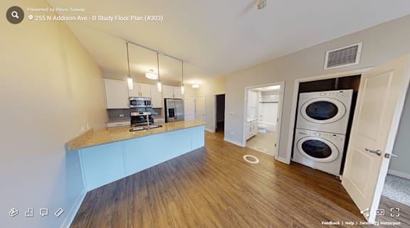 A kitchen with a washing machine in the doorway.