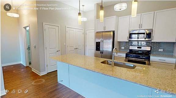 A kitchen with a refrigerator, microwave, and oven built into the countertop.