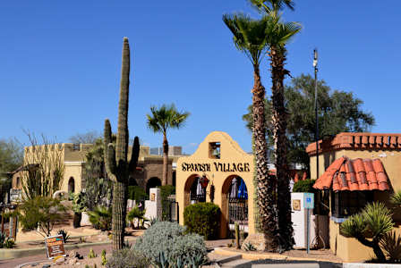 A Spanish Village restaurant with a tall cactus in front.