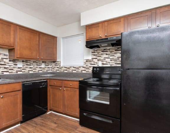 a kitchen with black appliances and wooden cabinets