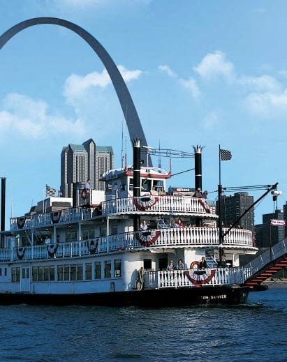 a large boat on the water in front of the gateway arch
