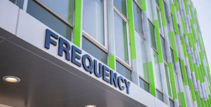 a sign on the side of a building that says frequency