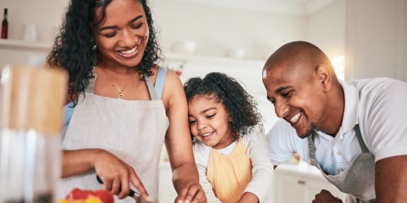 a family in the kitchen cutting up vegetables