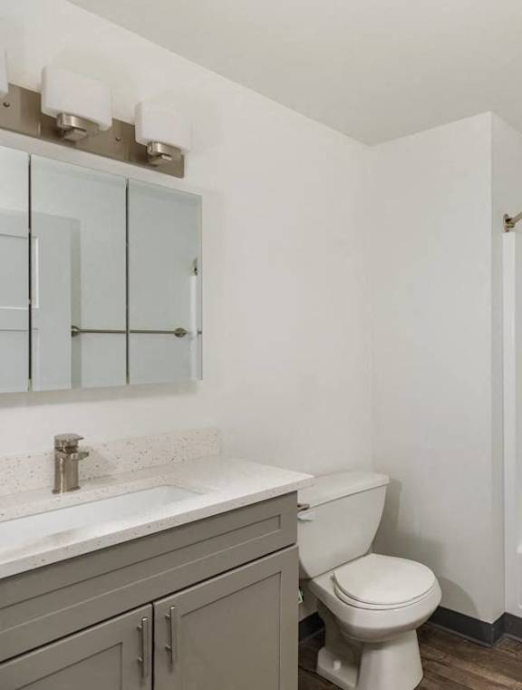A white bathroom with a toilet, sink, and shower.