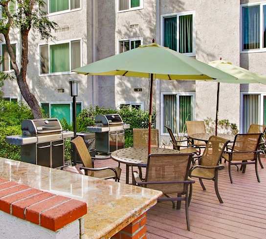 A patio with a table and chairs and an umbrella.