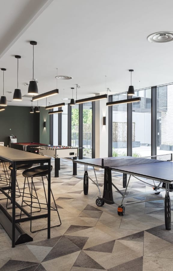 a game room with ping pong tables and a bar