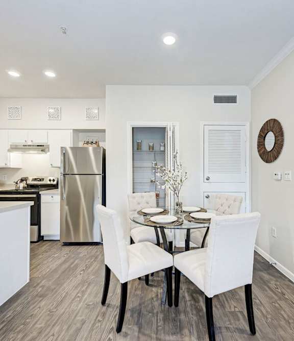 A modern kitchen with a dining table set for two.