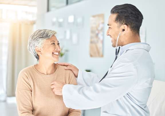 A doctor is checking the heartbeat of a patient.