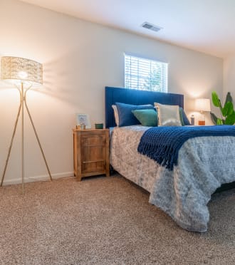 a bedroom with a bed and a lamp and a mirror