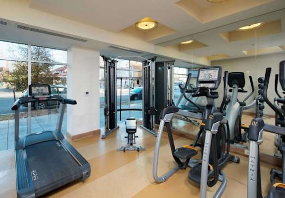 A gym with treadmills, elliptical machines, and other exercise equipment.