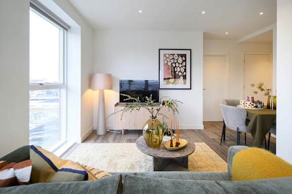 A living room with a grey couch and a yellow chair.