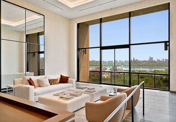 a living room with a view of the river and a couch and a table at Riello Apartments Owner LLC, New Jersey, 07020