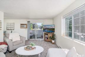 a living room with two couches a coffee table and a sliding glass door to a balcony at Ironwood Apartments, Coeur d'Alene, Idaho