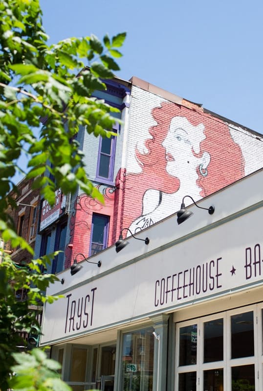 the facade of a restaurant with a mural on the side of the building