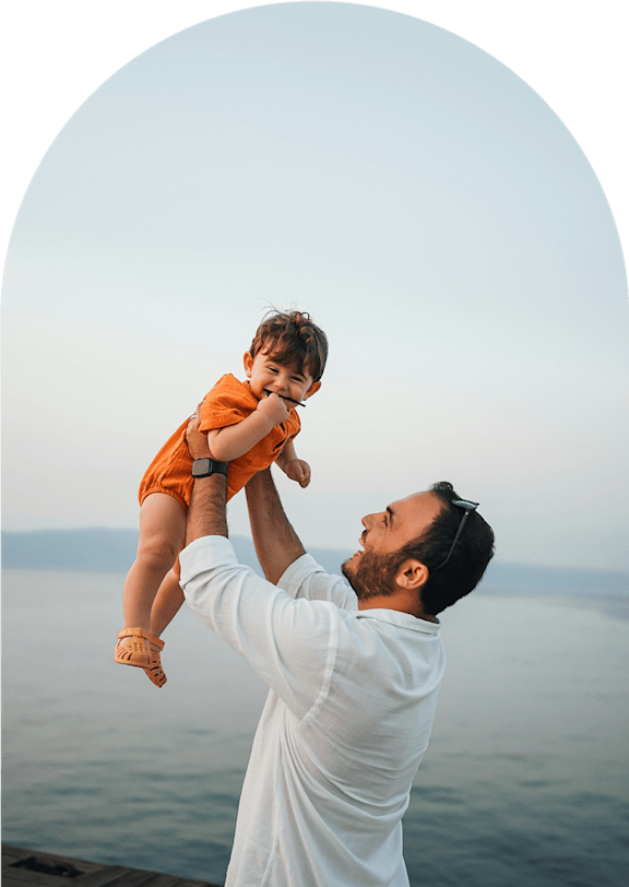 A man holding a child up in the air.
